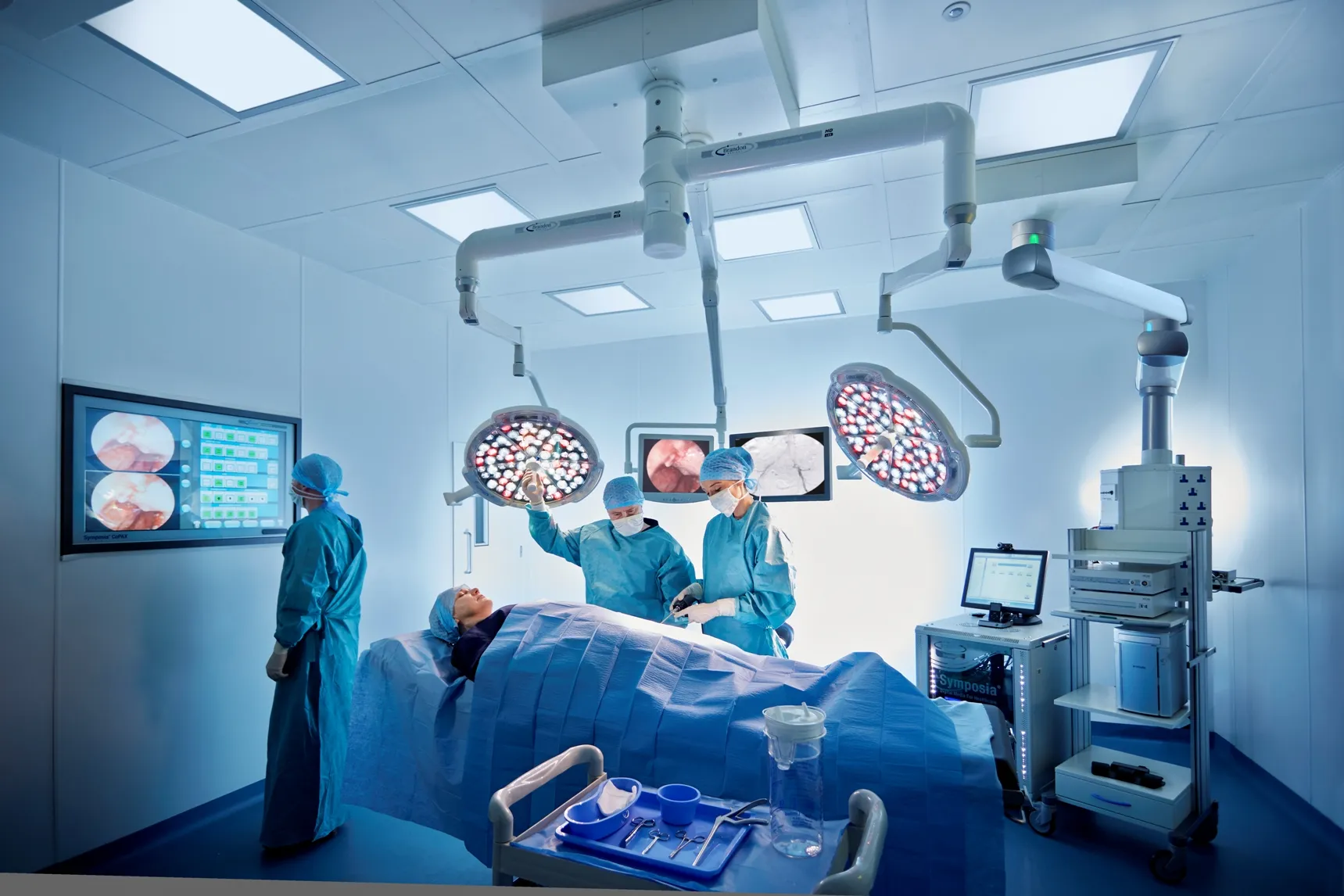 Medical team performing surgery in a high-tech operating room with advanced equipment and monitors.